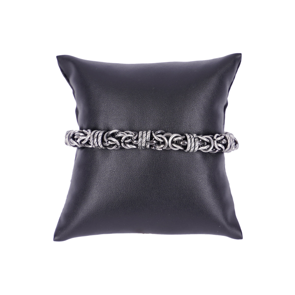 Massives Herrenarmband aus silberfarbenem Edelstahl mit dicker, dekorativer Kettenstruktur auf einem schwarzen Schmuckkissen.