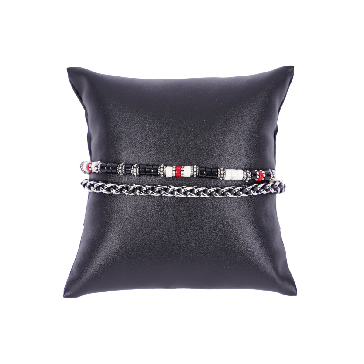 Zweilagiges Herrenarmband von Mancino aus einer silbernen Edelstahlkette und einer Perlenkette mit kleinen schwarzen, weißen und roten Stein-Rondelline auf einem schwarzen Kissen.