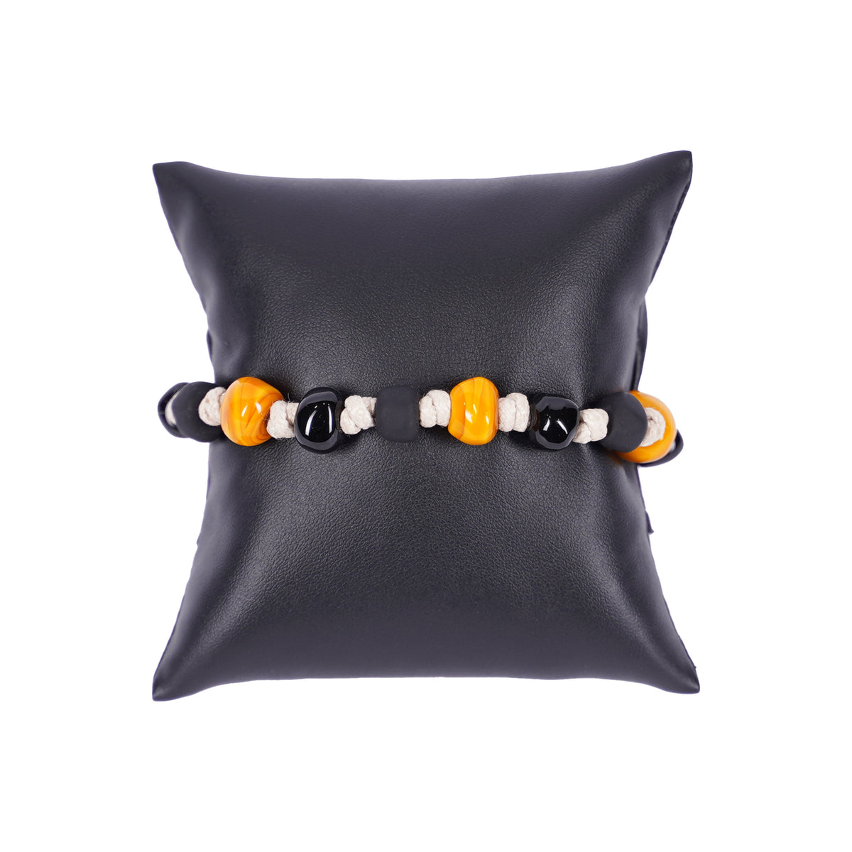 Herrenarmband von Mancino aus naturweißer geflochtener Kordel mit gelben und schwarzen Muranoglas-Perlen auf einem schwarzen Kissen.