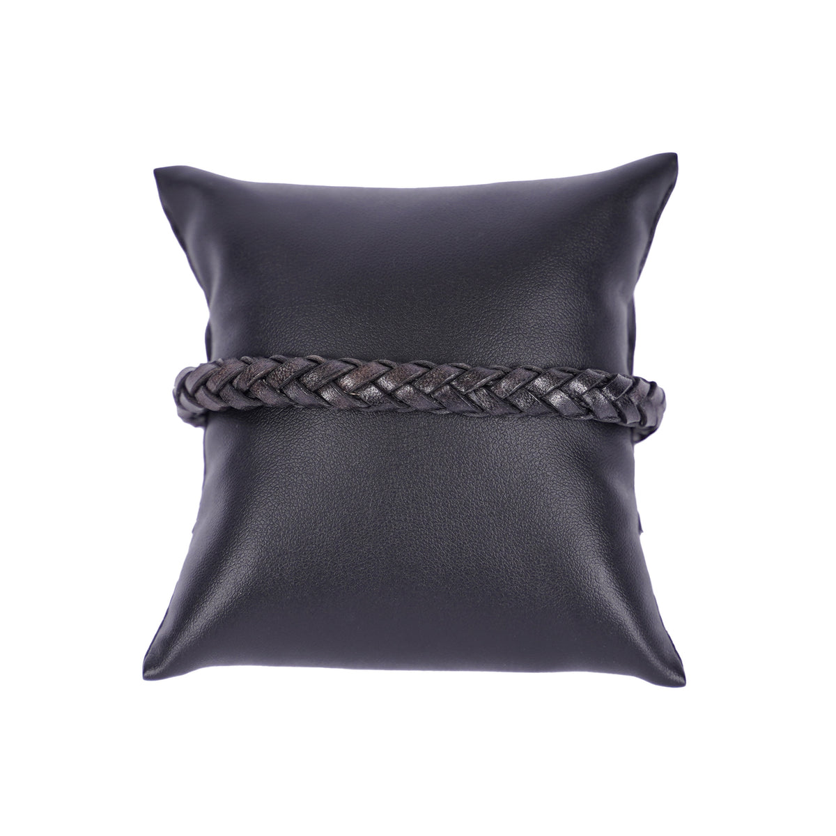 Dunkles, geflochtenes Mancino Lederarmband, elegant präsentiert auf einem schwarzen Präsentationskissen vor weißem Hintergrund. Hochwertige italienische Handwerkskunst.