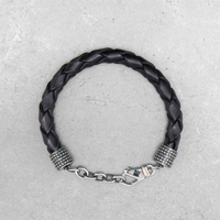 Schwarzes, geflochtenes Mancino Lederarmband Treccia Pelle für Herren bei Ricci Uomo. Markantes Design mit glänzenden Edelstahl-Endkappen und Karabinerverschluss.
