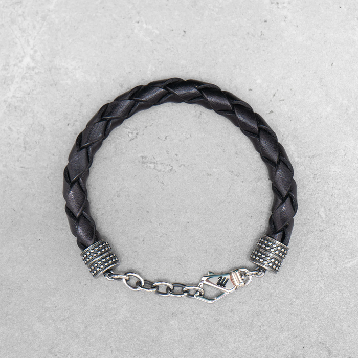 Schwarzes, geflochtenes Mancino Lederarmband Treccia Pelle für Herren bei Ricci Uomo. Markantes Design mit glänzenden Edelstahl-Endkappen und Karabinerverschluss.