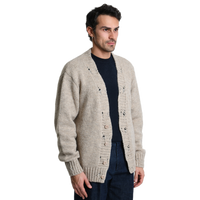Halbe Profilansicht des Xagon Cardigans in Beige. Die strukturierte Strickoptik, die Ton-in-Ton Knöpfe und die gerippten Bündchen an den Ärmeln unterstreichen das hochwertige, italienische Design.
