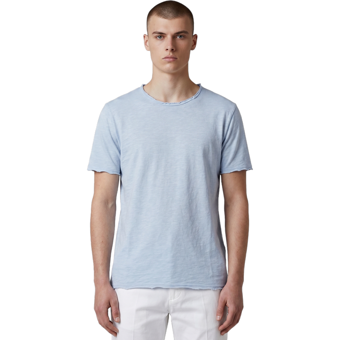 Frontansicht eines männlichen Models in einem hellblauen Slub-Cotton T-Shirt mit ungesäumten Raw-Edge-Abschlüssen und weißer Hose