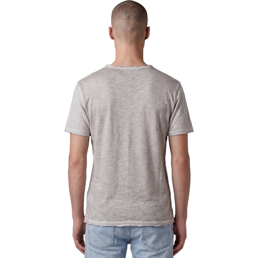Rückansicht eines männlichen Models in dem beigefarbenen T-Shirt. Der Fokus liegt auf der feinen Melange-Struktur des Stoffes, dem lässigen Schnitt und dem leicht ausgefransten Raw-Edge-Saum am unteren Bund. Das Model trägt eine hellblaue Jeans.