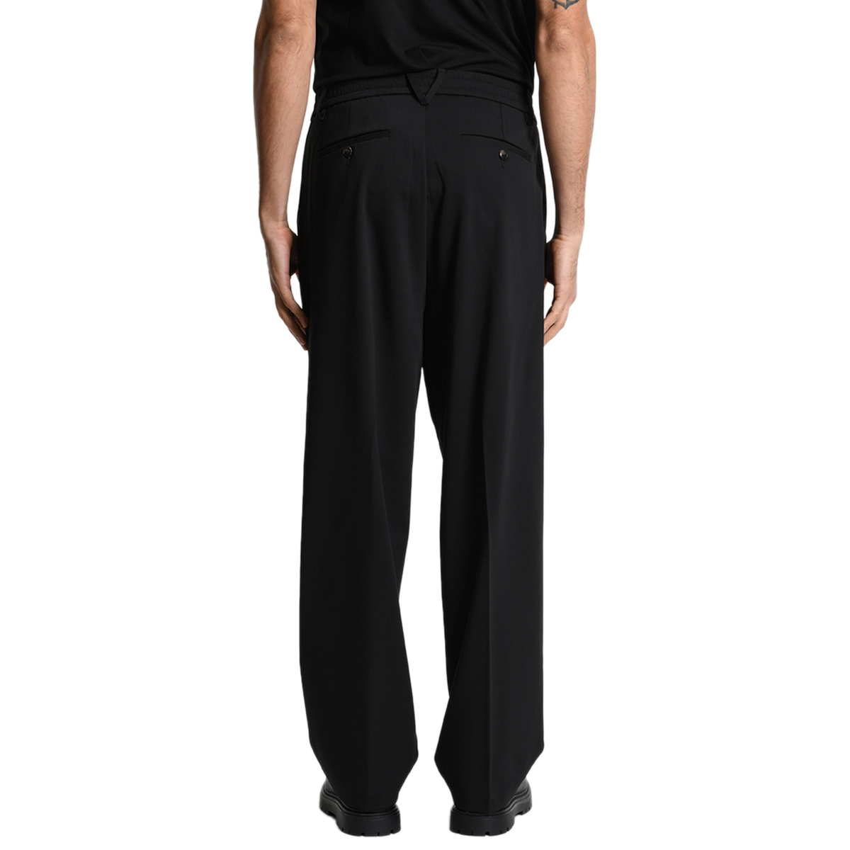 Rückansicht der Xagon Wide Fit Hose in Schwarz. Das cleane Design wird durch geknöpfte Paspeltaschen am Gesäß und den bequemen, elastischen Taillenbund abgerundet.
