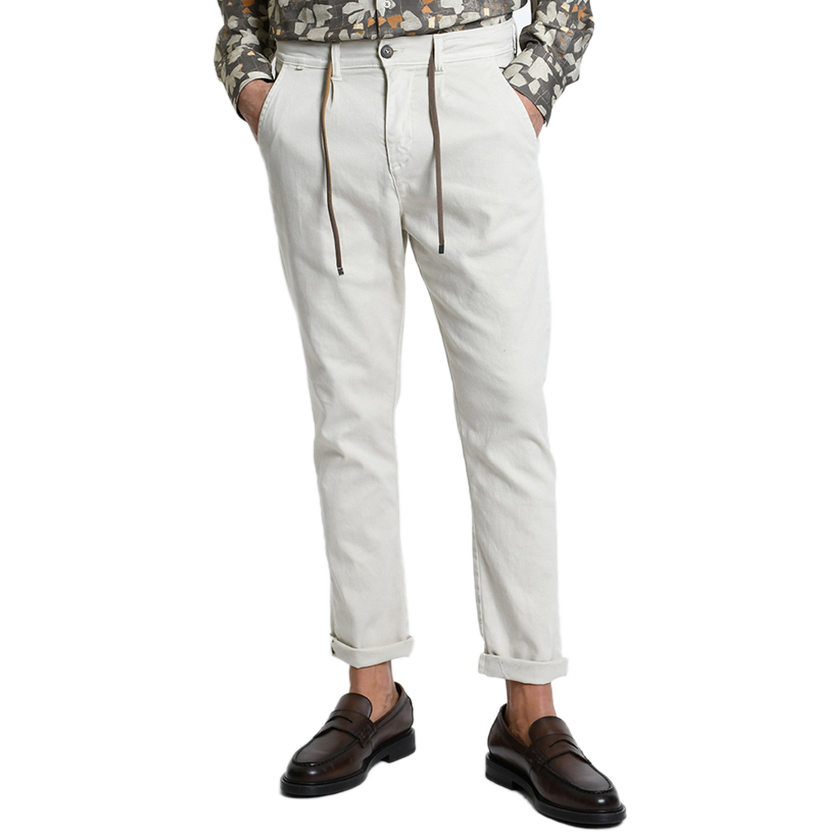 Vorderansicht der Xagon Comfort Fit Hose in Ecru bei Ricci Uomo. Das Model trägt die lässig umgekrempelte Hose mit Tunnelzug, Bundfalten und seitlichen Eingrifftaschen, elegant kombiniert mit dunkelbraunen Loafern.