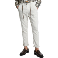 Vorderansicht der Xagon Comfort Fit Hose in Ecru bei Ricci Uomo. Das Model trägt die lässig umgekrempelte Hose mit Tunnelzug, Bundfalten und seitlichen Eingrifftaschen, elegant kombiniert mit dunkelbraunen Loafern.
