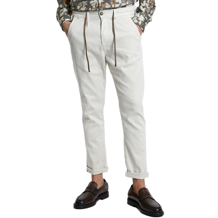 Vorderansicht der Xagon Comfort Fit Hose in Ecru bei Ricci Uomo. Das Model trägt die lässig umgekrempelte Hose mit Tunnelzug, Bundfalten und seitlichen Eingrifftaschen, elegant kombiniert mit dunkelbraunen Loafern.